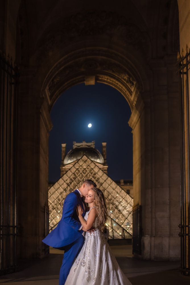 Just married couple in wedding clothing cuddling under moonlight