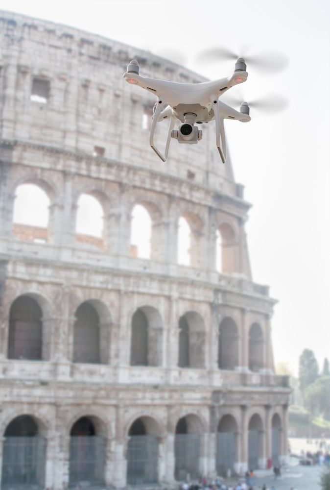 Unmanned Aircraft System Quadcopter Drone UAV In The Air Near The Colosseum In Rome.