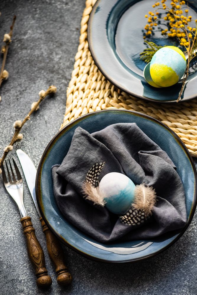 Top view of table setting with pastel egg decor and pussy willow