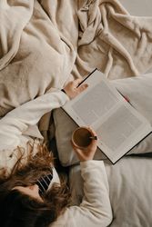 Person reading a book on the bed