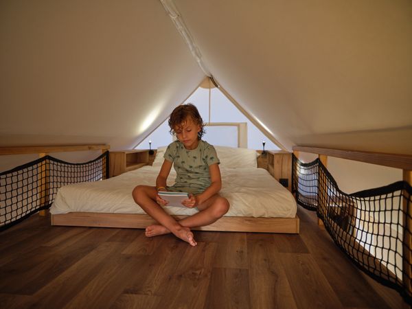 Boy sitting on bed reading