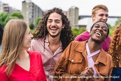 Multiethnic cheerful community of young friends gathering outdoors 5RVKMO