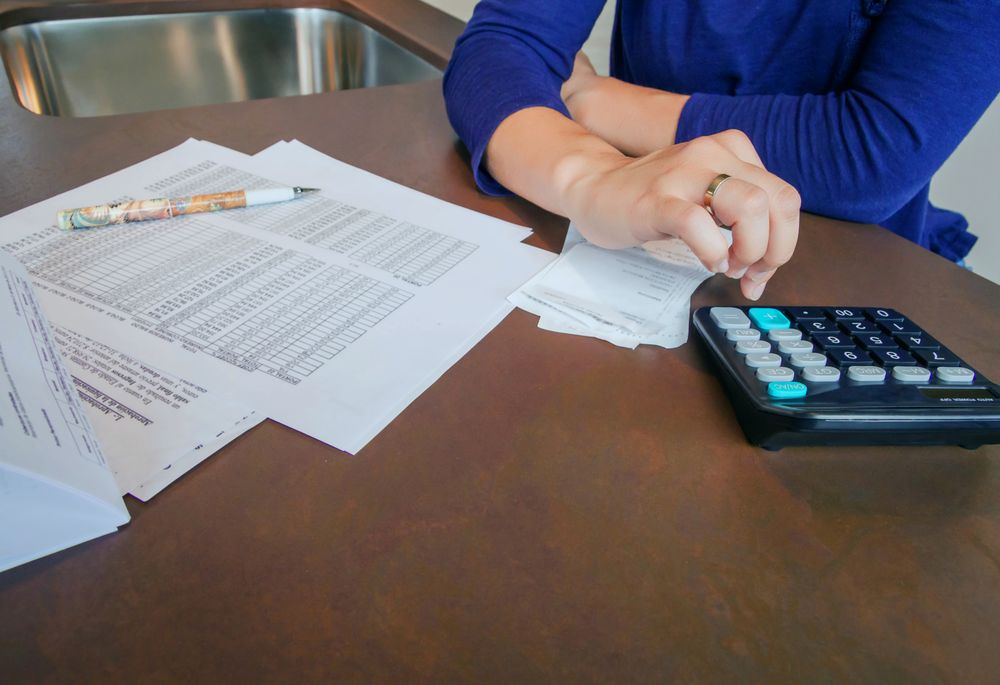 Woman calculating her monthly bills on kitchen counter