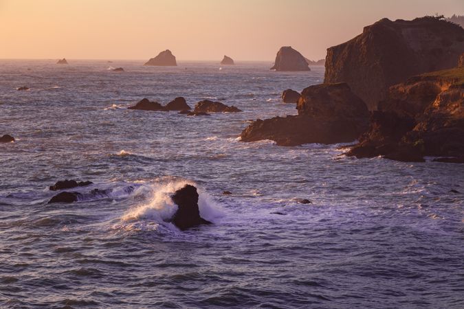 Cliffs and rocks in the ocean in late afternoon on the West Coast