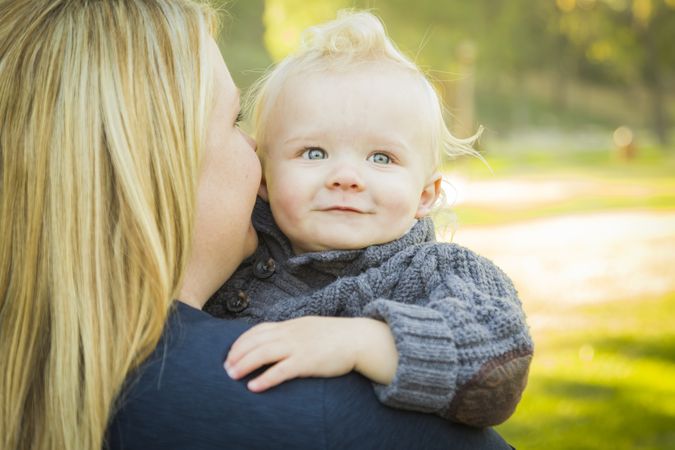 Mother Embracing Her Adorable Blonde Baby Boy.