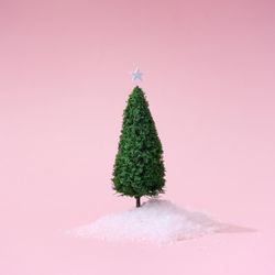 Christmas tree with snow on pastel pink background