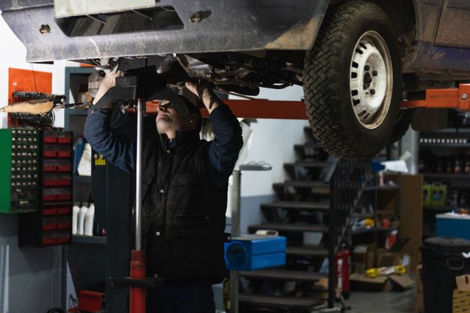Repairman removing car details with torch during work in auto service