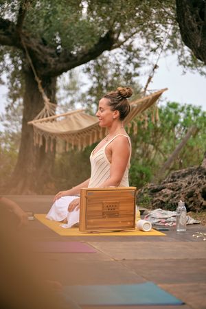 Woman practicing yoga on mat near shruti box