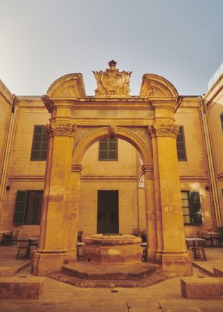 Courtyard in Malta with fountain under an arch