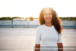 Relaxed content Black woman on roof top with sun setting behind her 5qzkw4
