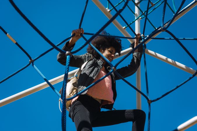 Woman with afro hair climbing by children's attractions.