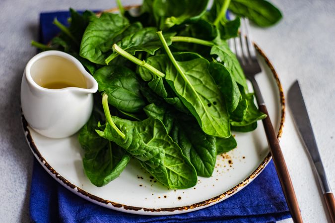 Plate of fresh spinach salad on table