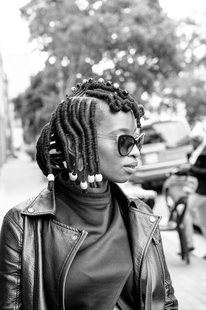 Side view of woman with African braids walking on the sidewalk