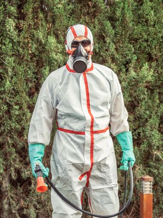 Man in suit for fumigation in yard