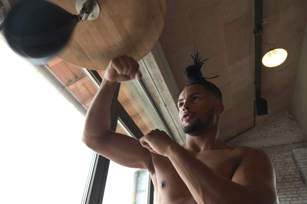 Black guy boxing in gym