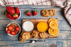 Glasses near fruits and cookies on table near napkin