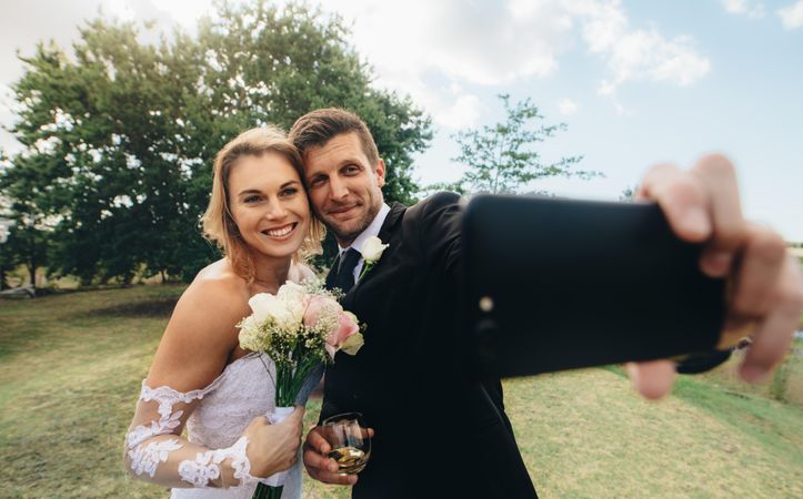 Happy husband and wife do selfie on wedding day