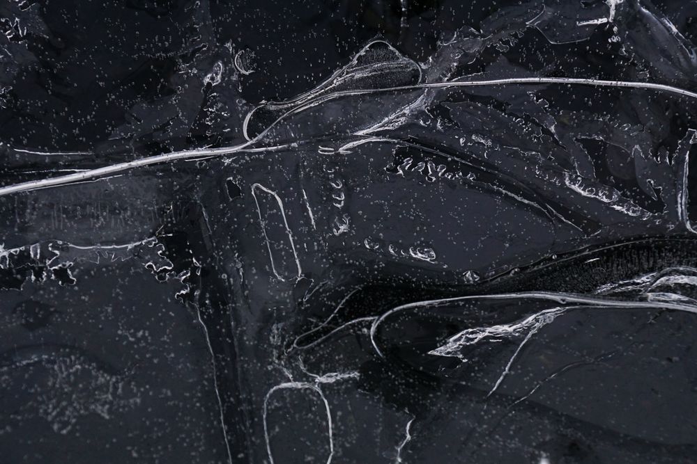 Fragment of thin ice on dark frozen river