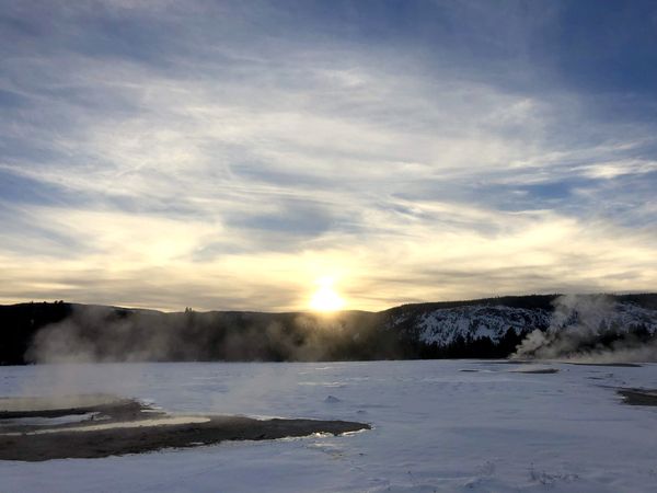 Sunset Serenity: Snowy Landscape and Rising Vapor in the Glow of Twilight