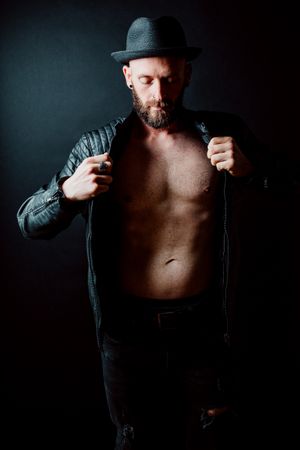 Young shirtless bearded guy in leather jacket