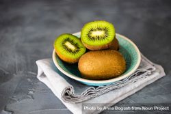 Bowl of kiwi fruits with one halved on top bGRvJv