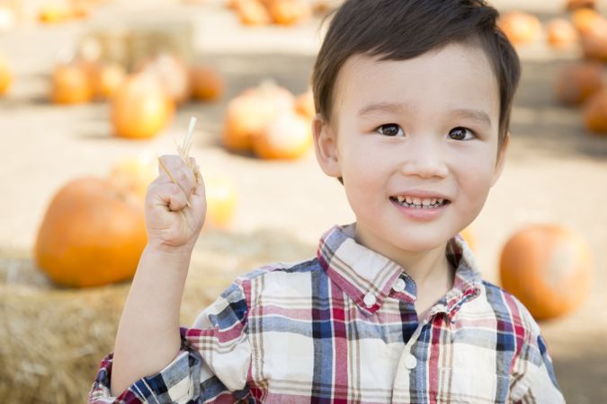 Content Young Boy Having Fun at the Pumpkin Patch
