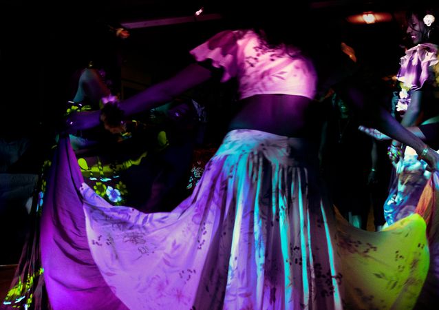 Woman holding skirt and dancing at night