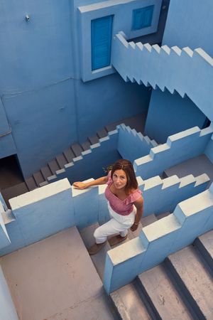 Woman walking downstairs on modern blue building