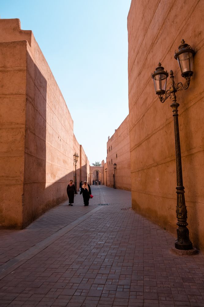 Two women wearing hijab walking in al alley