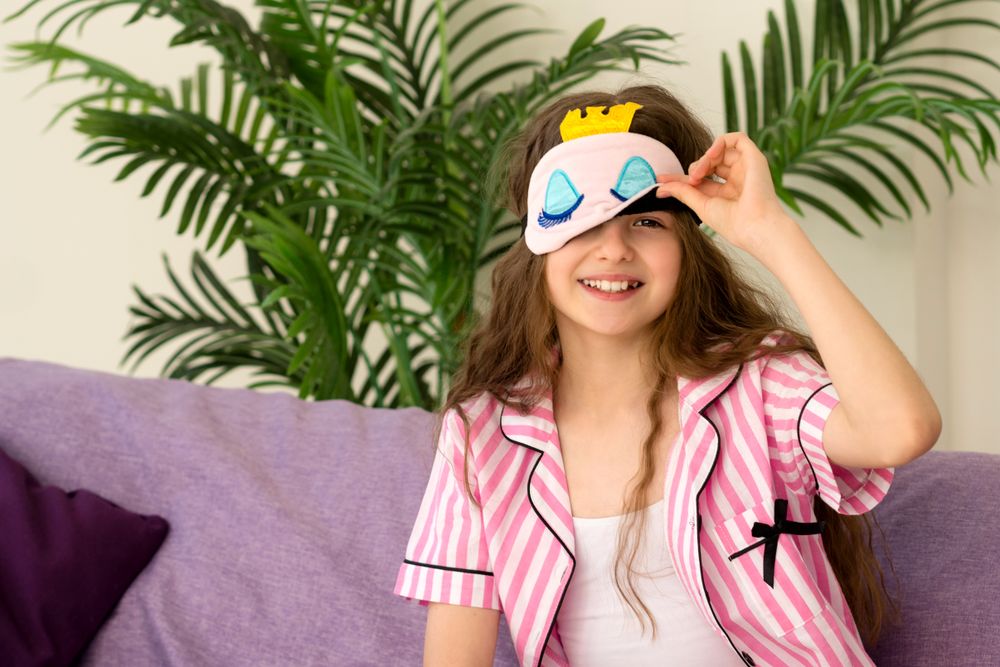 Young girl adjusting sleep mask