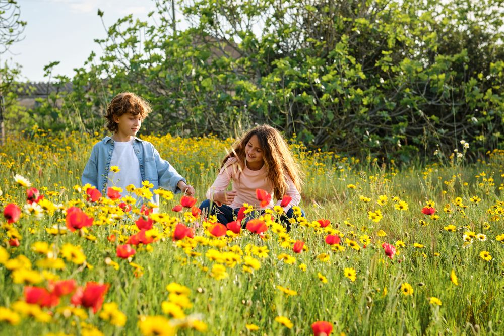 Boy and girl resting in blooming field