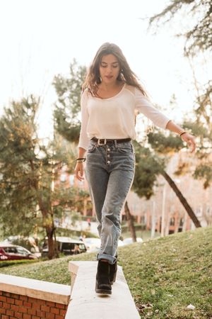 Young woman walking on border in park