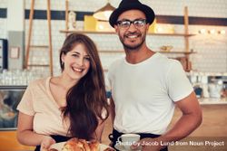 Portrait of happy young man and woman holding their lunch in a cafe looking at camera and smiling 5aXYd0