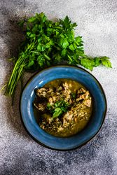 Top view of Georgian chakapuli stew with fresh herbs