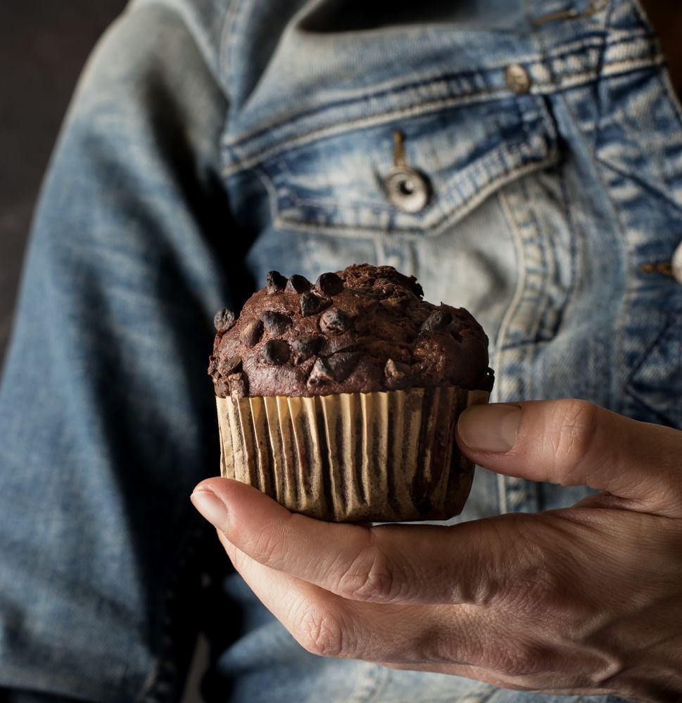 Crop woman with chocolate banana muffin