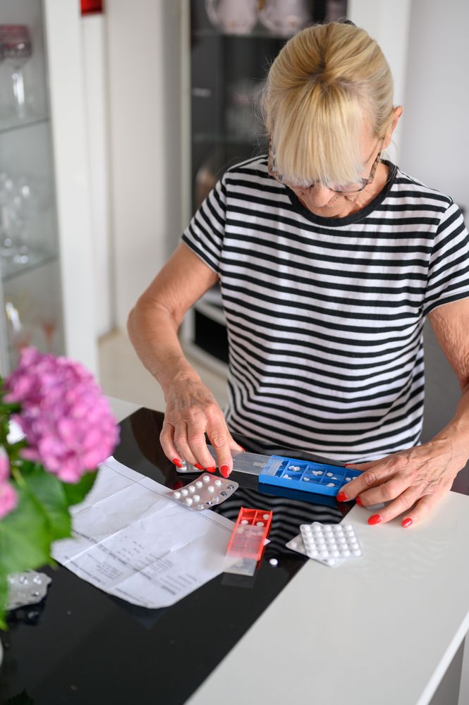 Focused woman putting pills in pill box