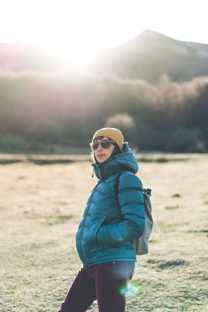 Traveler with backpack walking on autumn field