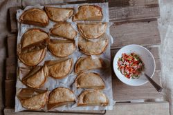 Baking tray with composed freshly baked pies patty