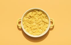 Scrambled eggs above view minimalist on an orange background