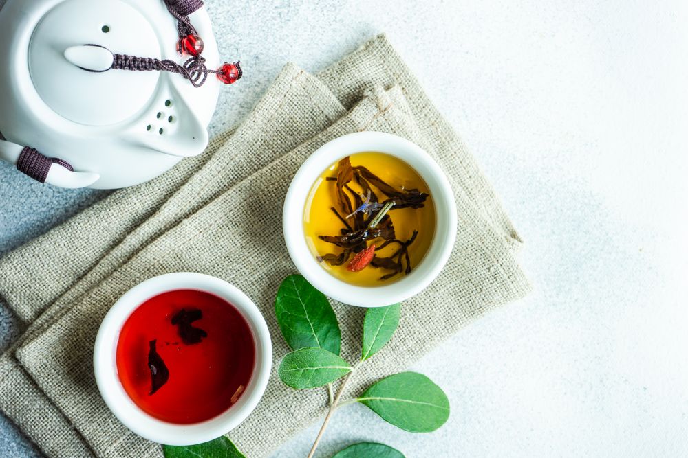 Two cups of tea on napkin with tea pot