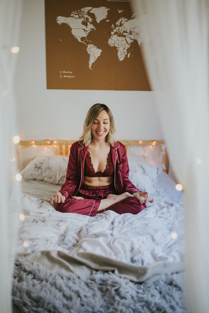 Young woman meditating on bed
