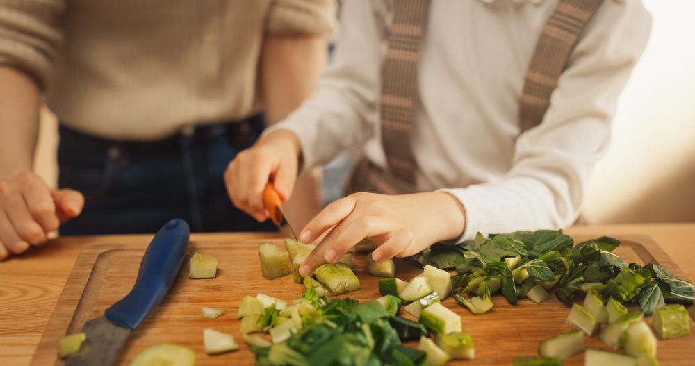 Korean Mother and Cute Little Daughter Cooking Together Healthy Dinner in their Home Kitchen.