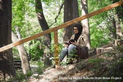 Muslim woman calmly reading a book on park stairs 4m3BN0