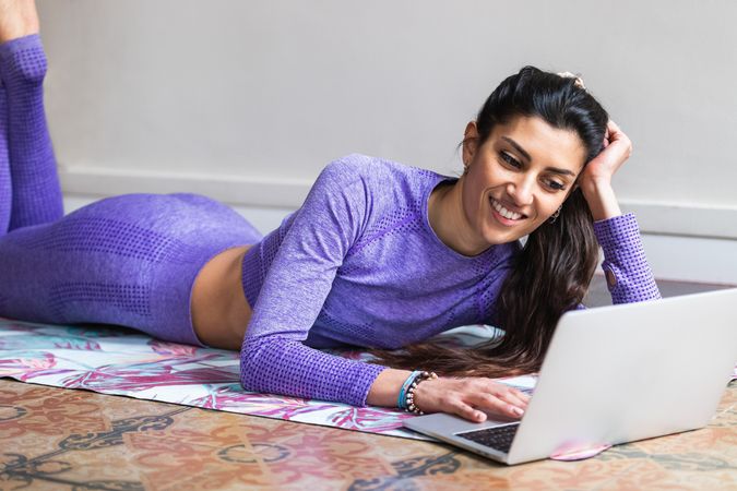 Woman using laptop during yoga training at home
