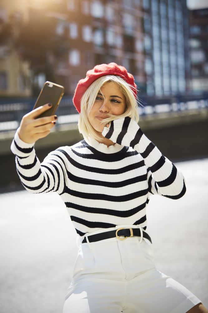 female in red beret taking selfie