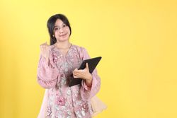 Happy Asian Woman with Indonesian Kebaya using Tablet Phone