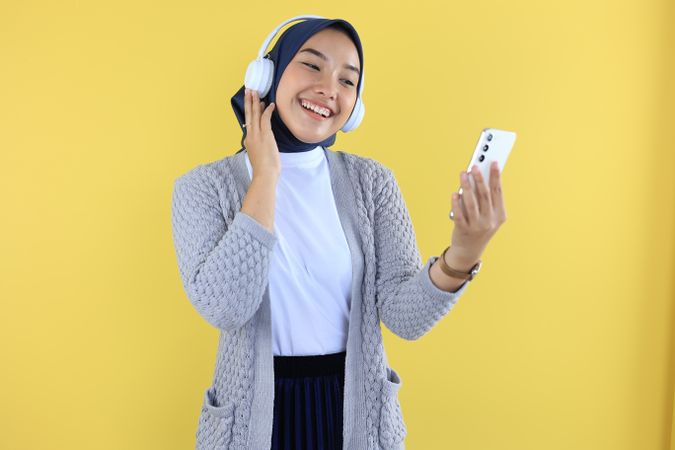 Young Muslim Woman Playing Music on Her Phone and Hearing with Headphone