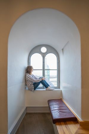 Relaxed woman resting in window sill