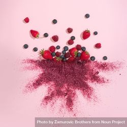 Mixed berries with red dust on pink background 5ppxg5