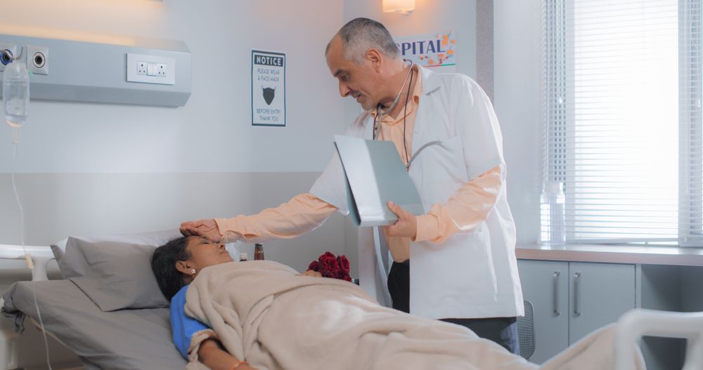 Indian Hospital Ward: Friendly Doctor Talks to Female Patient Resting in Bed, Explains Test Results, Gives Recovery Advice.